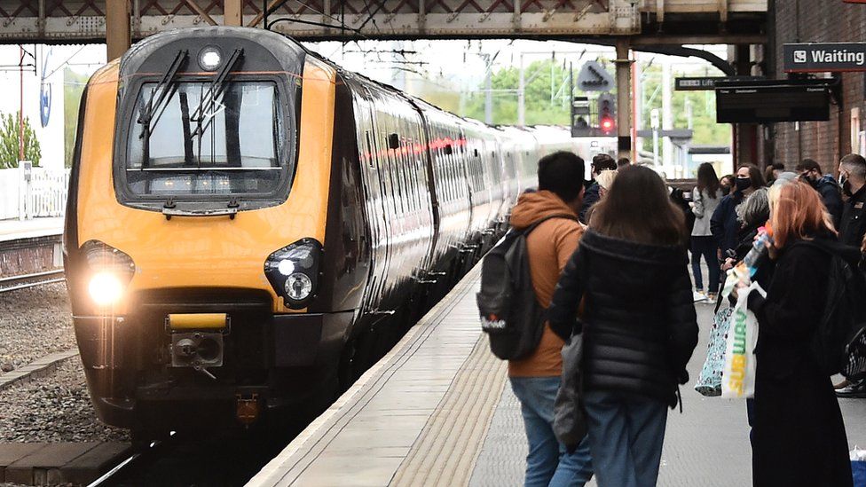 Passengers wait outside an Avanti train in Stoke