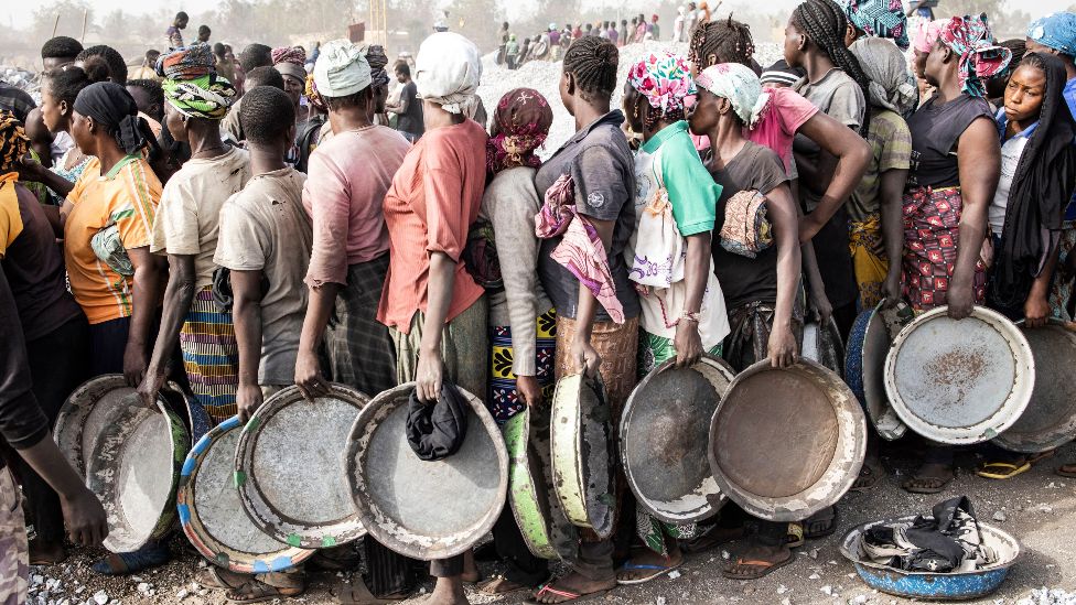 Women wait in line to collect their pay at the Pissy Granite Mine, Ouagadougou, Burkina Faso - Friday 28 January 2022