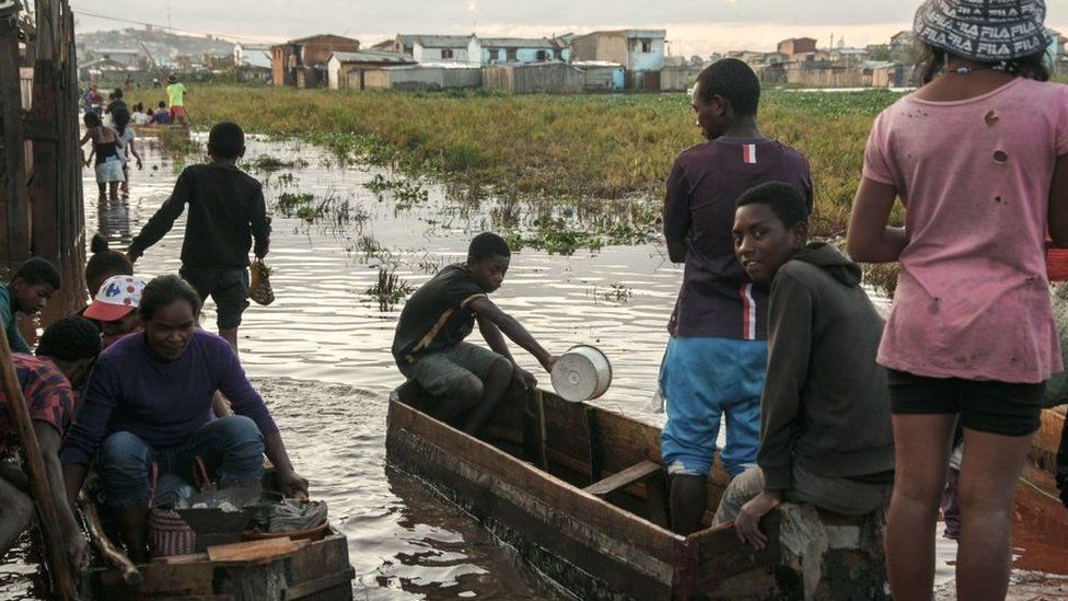 Residents of the 67-hectare Ankasina flooded neighbourhood use makeshift boats to reach their homes in Antananarivo on Januray 28, 2022