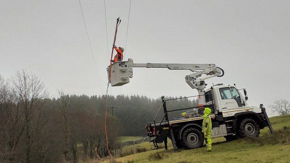 Electricity worker checking overhead power line