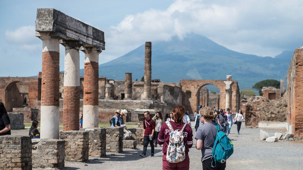 Tourists looking at the ruins of the forum at Pompeii.