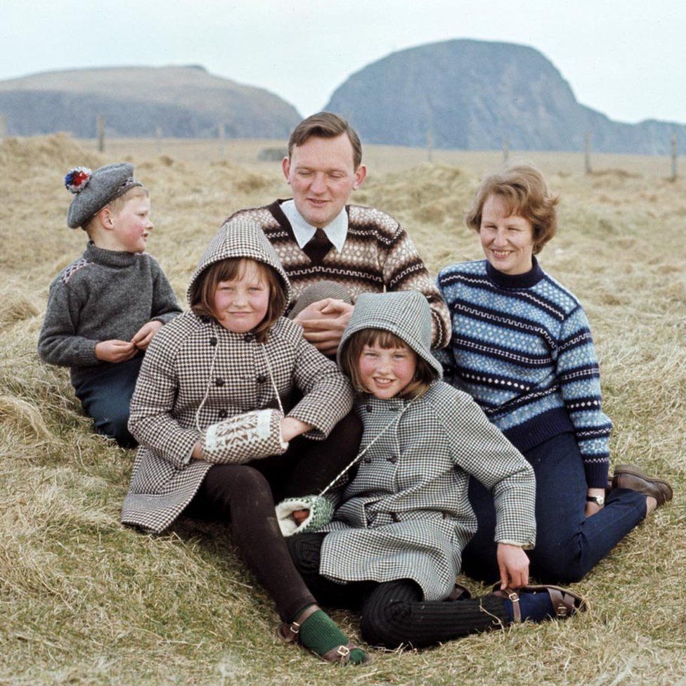 A man and woman wearing Fair Isle jumpers pose with three children on one of the Shetland Islands in 1970.
