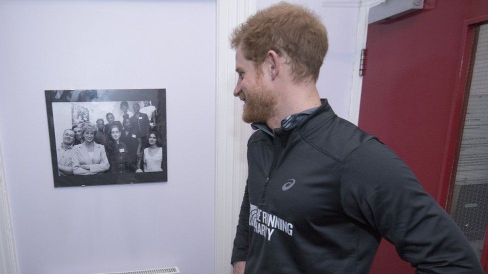 Prince Harry looks at a picture of his mother Diana, Princess of Wales, after arriving at Depaul Trust Hostel