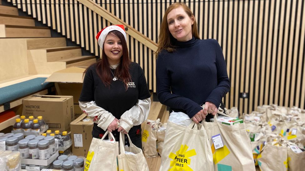 Cheyenne and development officer at Children in Wales, Kate Aubrey, packing food bags