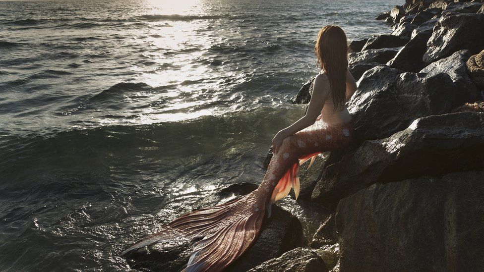 Mermaid watching sunset - stock photo