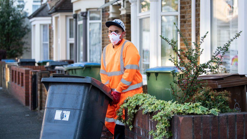 Refuse collector wearing a mask