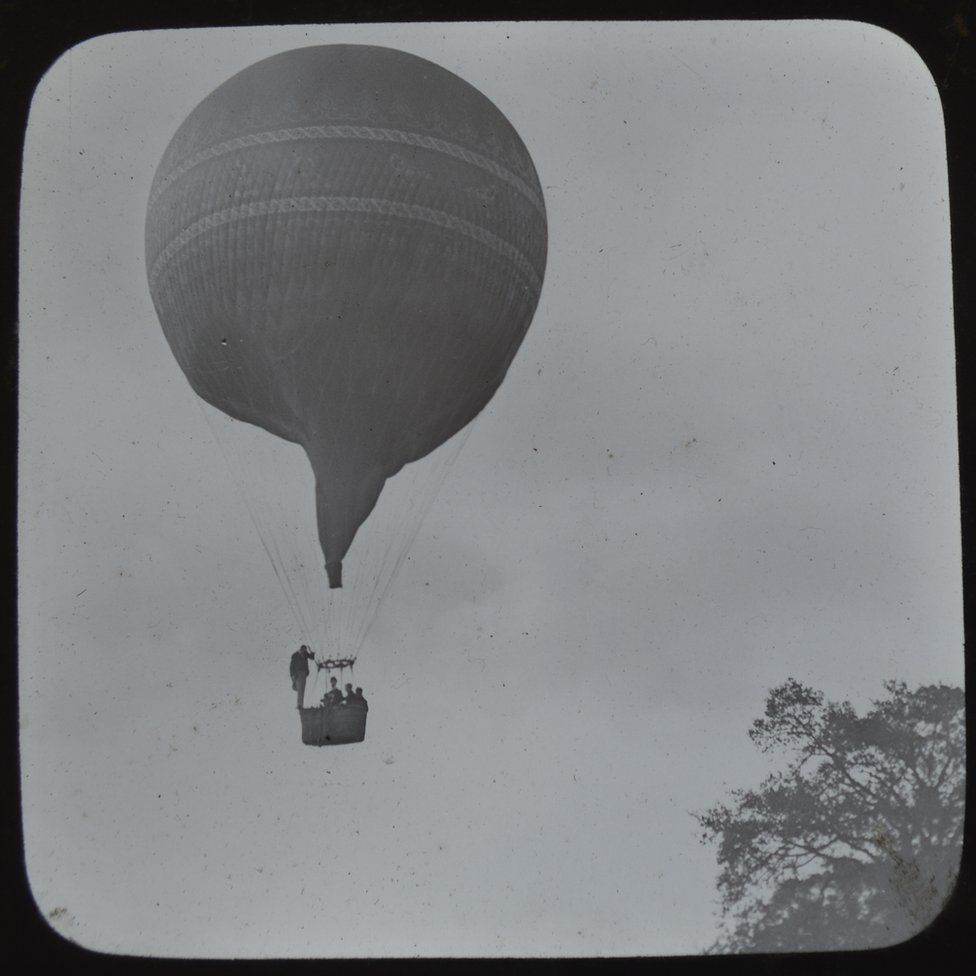 Balloon flight with man standing on the edge of the basket