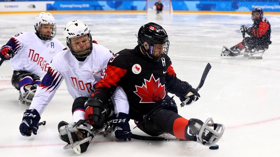 Canada battles for the puck with Norway in ice hockey during the 2018 Paralympic Games