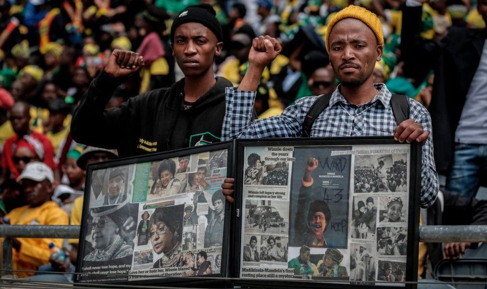 Mourners with raised clinched fists stand watching from the stands of the full 37,500-seater Orlando Stadium, in the township of Soweto, the funeral of the late anti-apartheid champion Winnie Madikizela-Mandela, concluding 10 days of national mourning on April 14, 2018, in Johannesburg. South Africans turned out in their thousands to bid final goodbyes to anti-apartheid icon and Nelson Mandela's former wife who was laid to rest with full state honours. Winnie Mandela, who died in Johannesburg aged 81 on April 2 after a long illness, has been celebrated for helping keep Nelson Mandela's dream of a non-racial South Africa alive while he was behind bars for 27 years.