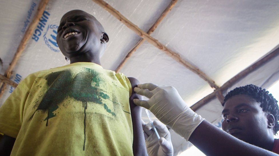 A refugee being administered a jab