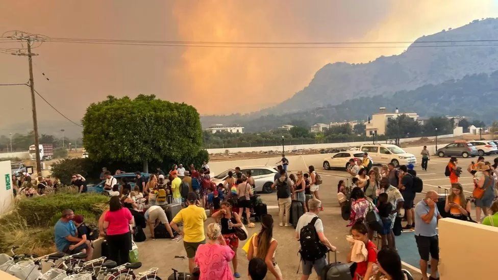 Smoke in Rhodes as people wait outside a hotel