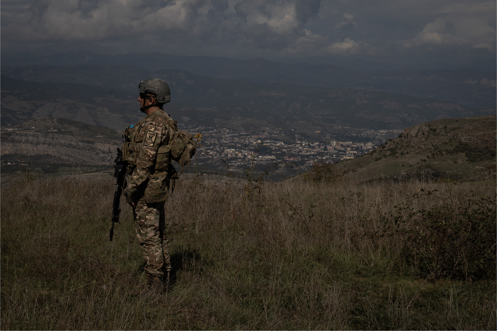 An Azerbaijani soldier stands at a retaken outpost overlooking the city of Stepanakert, Nagorno-Karabakh