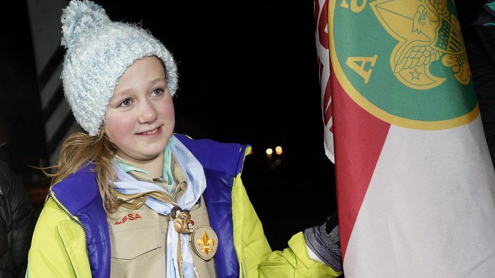 Vaughn stood next to her scout troop's flag