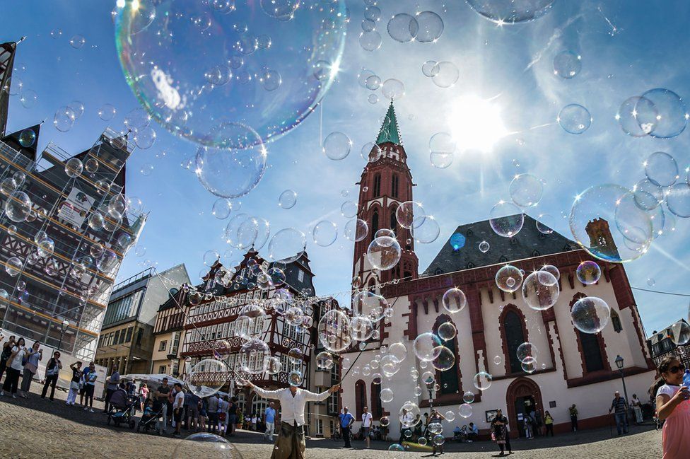 A street artist makes soap bubbles in front of the Alte Nikolaikirche at the Roemerberg Square in Frankfurt, Germany on 12 August 2018.
