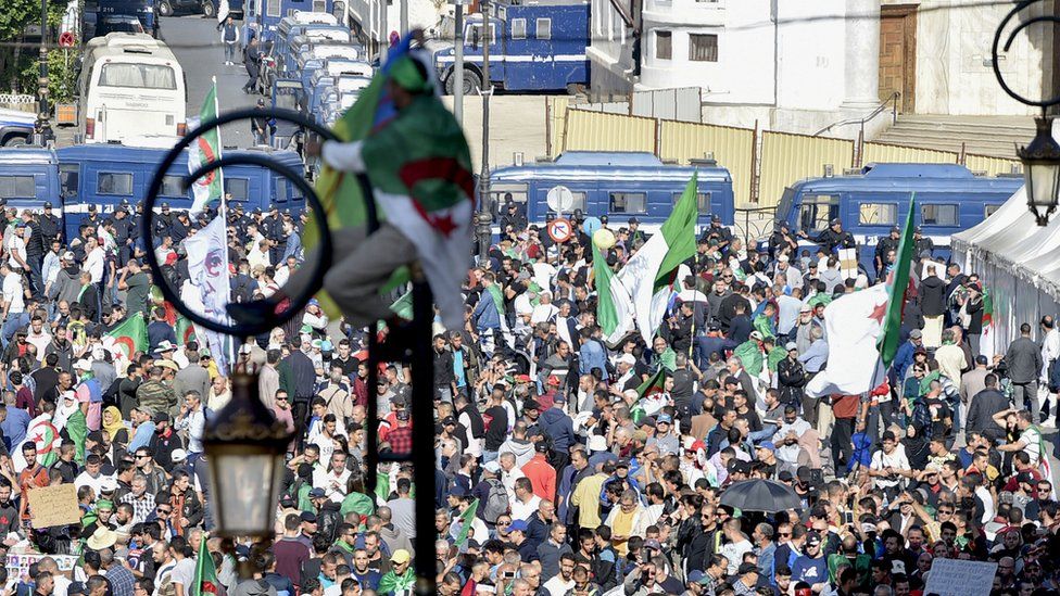 Algerians take part in an anti-government demonstration in the capital Algiers on November 1, 2019. - Demonstrators converged on Algiers in their thousands for a massive anti-government rally called to coincide with official celebrations of the anniversary of the war that won Algeria's independence from France.