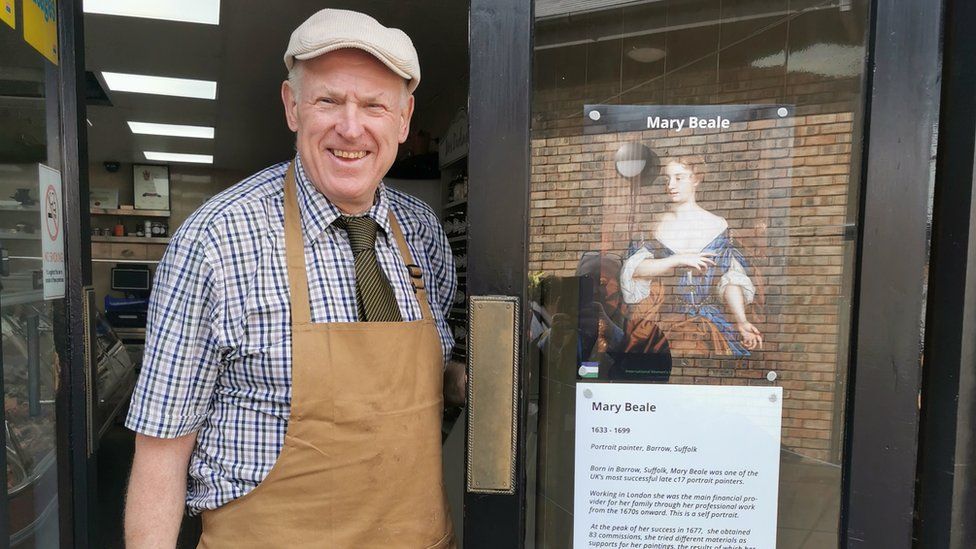 Eric Reeve standing next to his storefront, which contains information about Mary Beale