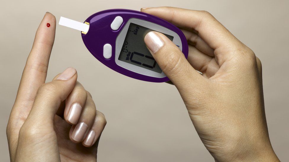 A finger being pricked for a blood glucose test