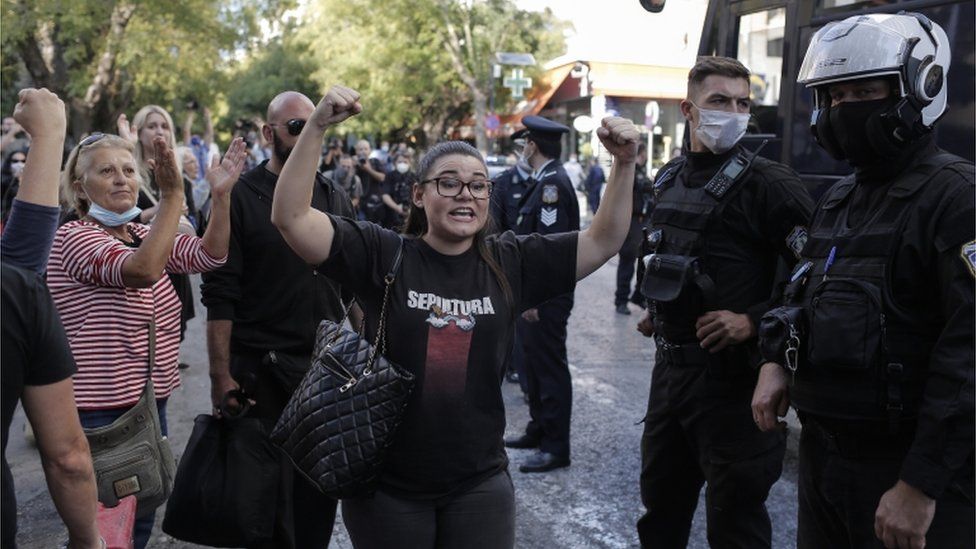 Ourania Michaloliakou, daughter of the convicted leader of the ultra-right party of Golden Dawn Nikos Michaloliakos, yells to journalists outside the headquarters of the Greek Police