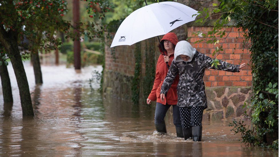 Local residents make their way through floodwater in Cossington, Leicester after torrential thunderstorms and the village"s proximity to the River Soar has seen parts of the village flooded