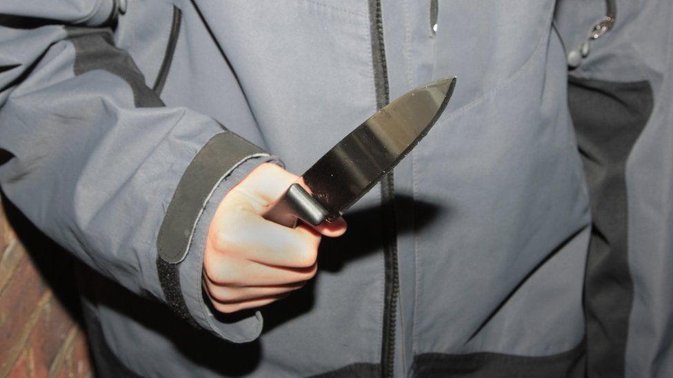 Teenage boy holding a knife