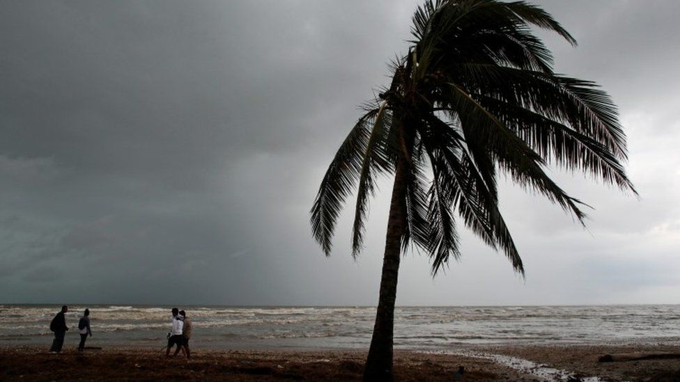 People walk along a beach after the passing of Hurricane Iota Nicaragua