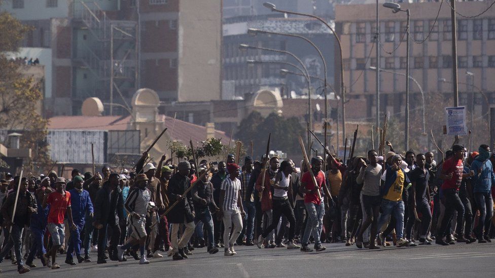 Сторонник бывшего президента Джейкоба Зумы во время продолжающихся жестоких столкновений в центре Йоханнесбурга, Южная Африка, 11 июля 2021 года.
