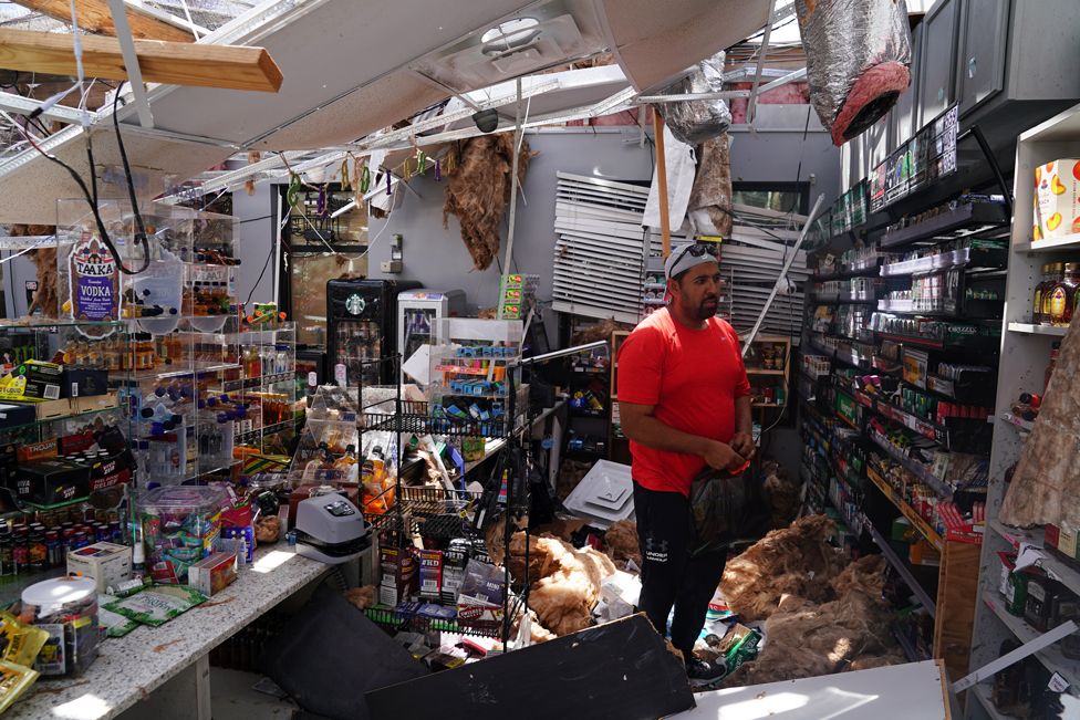 Ahmed Nawaz surveys the damage to his store in Louisiana