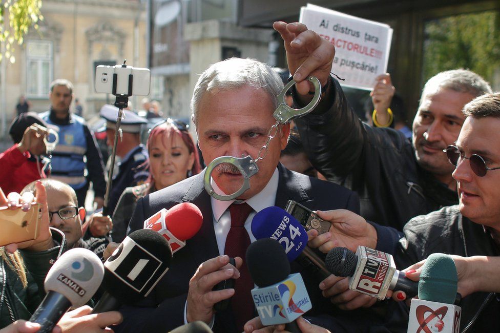 A protester waves a pair of handcuffs in front of Social Democrat Party leader Liviu Dragnea in Bucharest, Romania, October 3, 2017