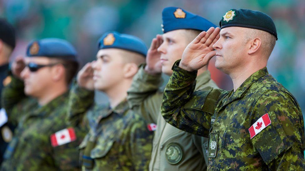 Военнослужащие канадских вооруженных сил отдают честь во время исполнения государственного гимна перед игрой между BC Lions и Saskatchewan Roughriders на стадионе Mosaic 13 августа 2017 года в Реджайне, Канада