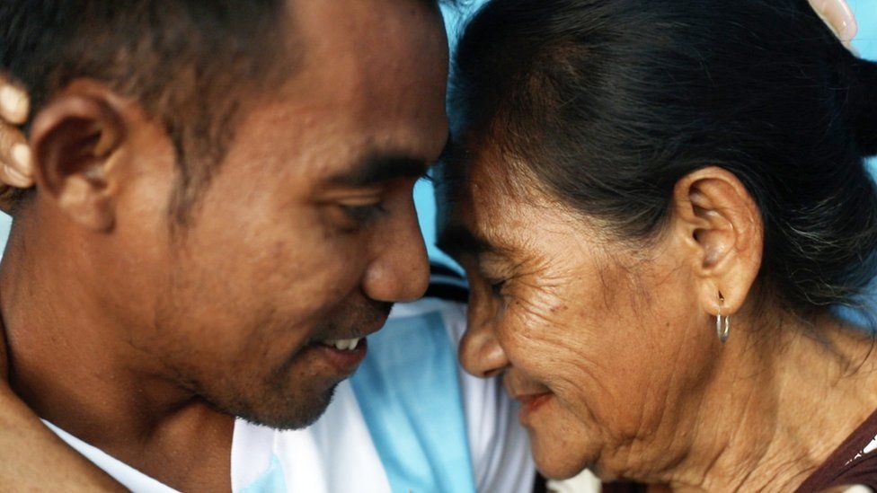 Siti Rudy and Abdul touch their heads together in an embrace at home in Indonesia