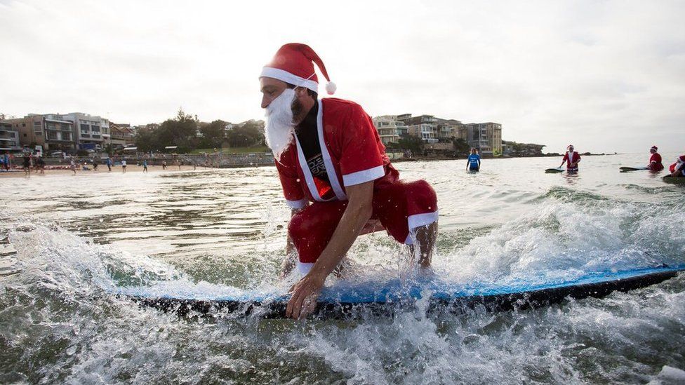 A pack of 320 surfing Santas embrace the Christmas spirit in Australia, breaking the Guinness World Record for the largest surf lesson.