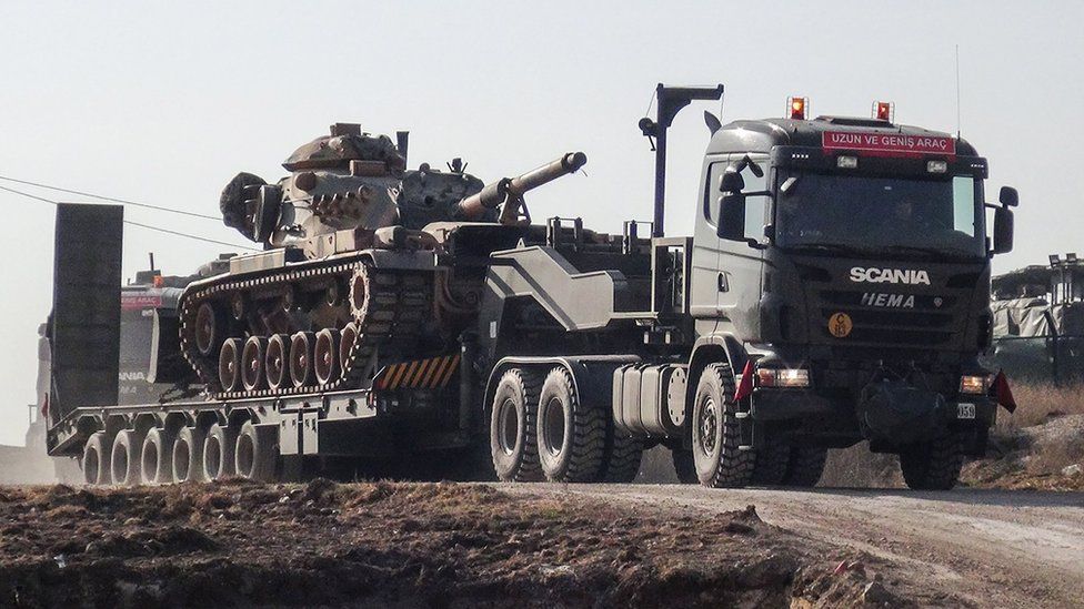 A photo made available by the Dogan New Agency shows Turkish military trucks transporting a tank to the border with Syria near Sanilurfa on 16 January 2018