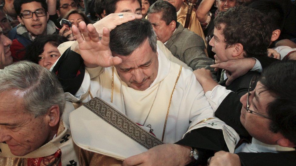 Bishop Barros attends a service amid protests