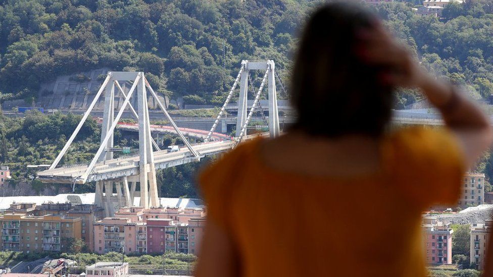 A woman looks at Genoa's shattered bridge. 16 August