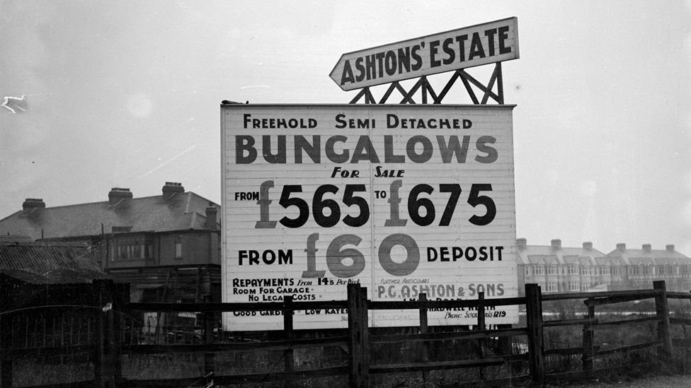 1937: A sign advertising freehold semi-detached bungalows for sale in Chadwell Heath, Essex