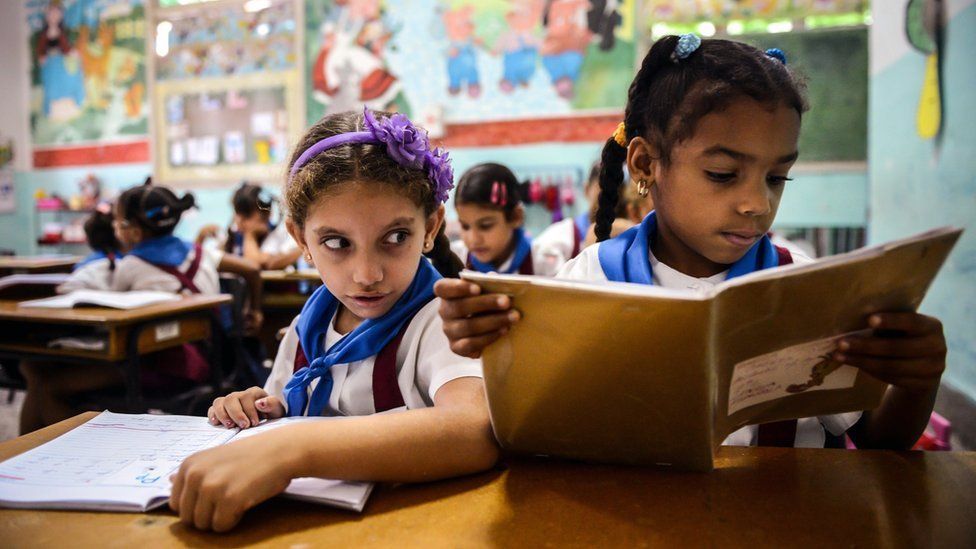 Cuban schoolgirls read during class in Havana