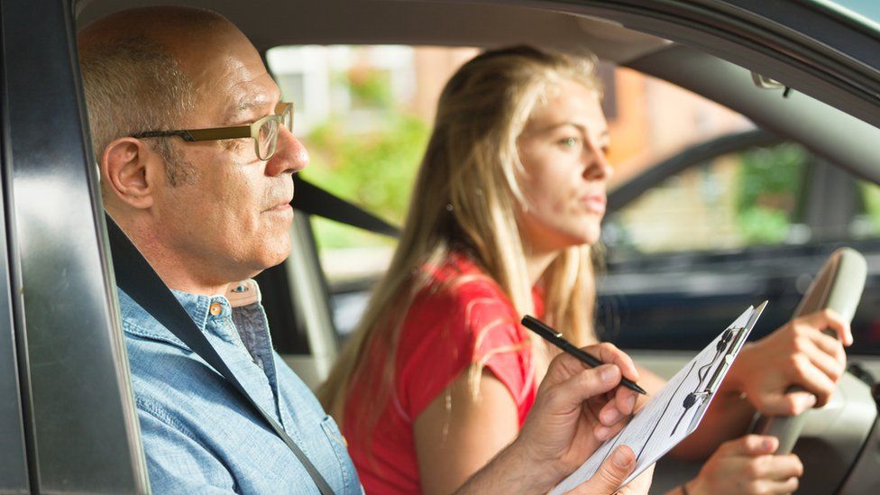 Driving examiner with woman doing test