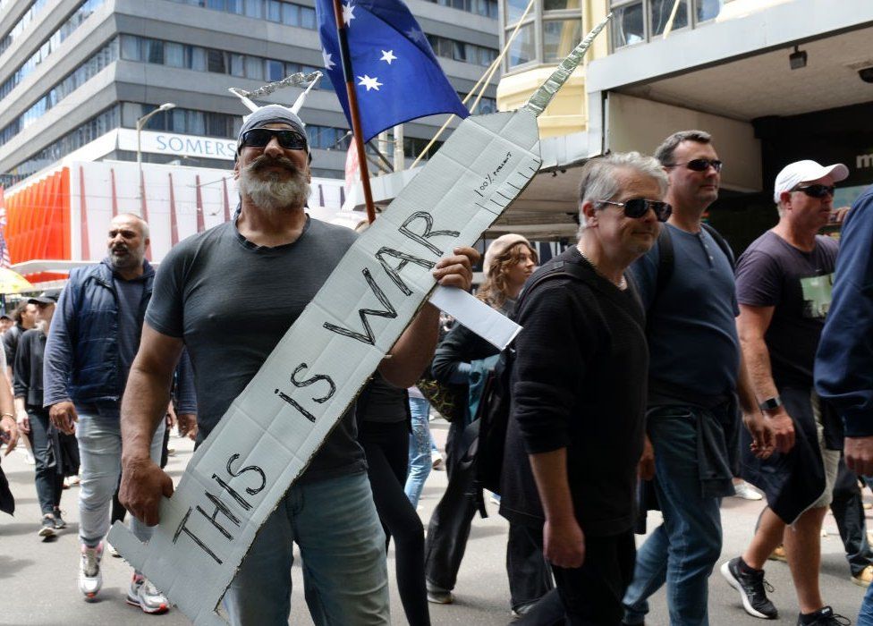 'This is a war': A protester holds up a needle sign in Melbourne, Australia