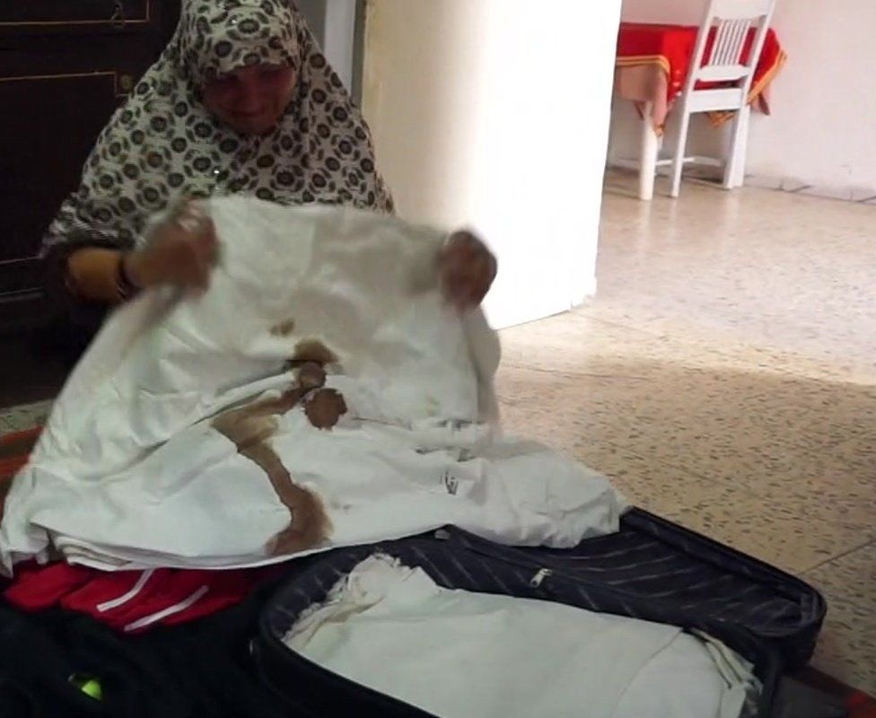 Sayeda weeps into bloodied sheet taken from her suitcase