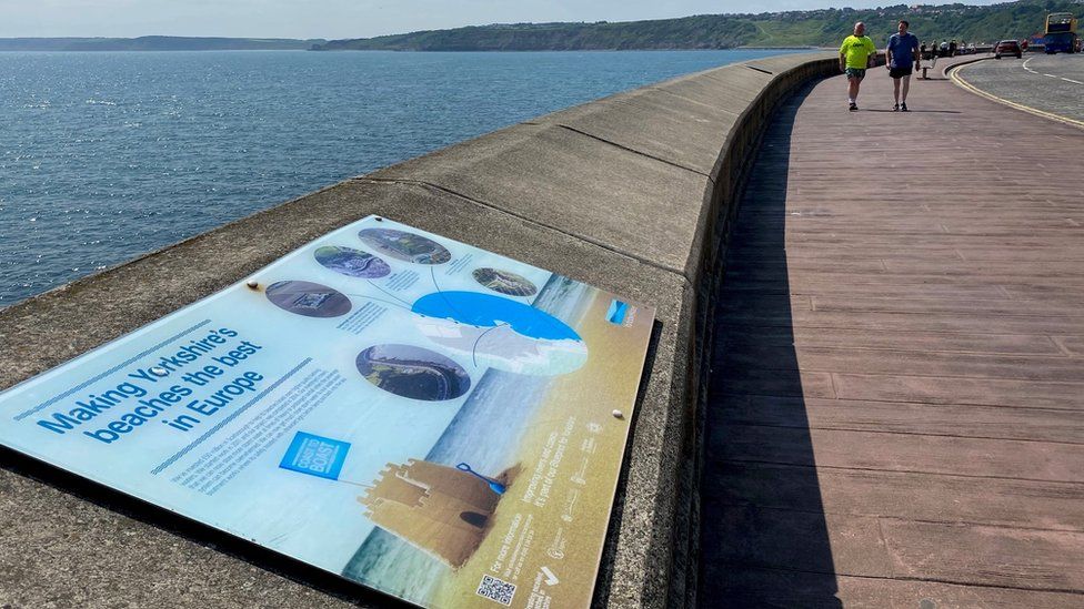 A Yorkshire Water sign on Marine Drive details past work to improve water quality