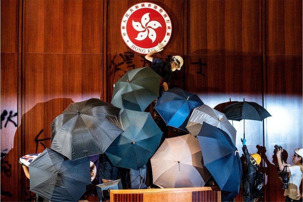 A protester defaces the Hong Kong emblem after protesters broke into the government headquarters in Hong Kong on 1 July 2019, on the 22nd anniversary of the city's handover from Britain to China