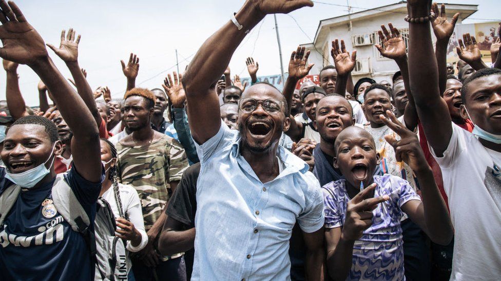 Supporters of incumbent Congo President Denis Sassou Nguesso (not visible) wave to the president after he cast his ballot in Brazzaville on March 21, 2021.