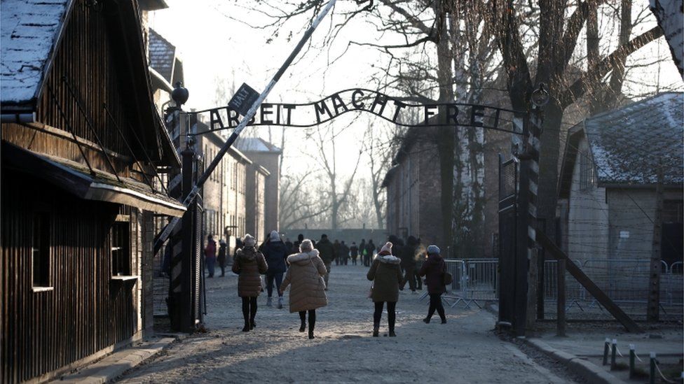 People walking through the infamous gate at Auschwitz, reading Arbeit Macht Frei - or work sets you free. File photo