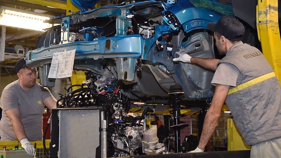 Employees work on the assembly line at a plant of French multinational automobile manufacturer Renault in Moscow in 2016