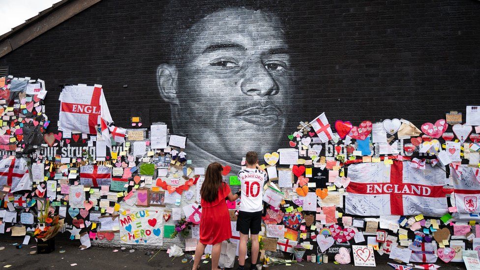 Mackenzie Robertson and his mother Sally Coles-Robertson put up a message on the mural of Manchester United striker and England player Marcus Rashford on the wall of the Coffee House Cafe on Copson Street, Withington. The mural appeared vandalised on Monday after the England football team lost the UEFA Euro 2021 final.