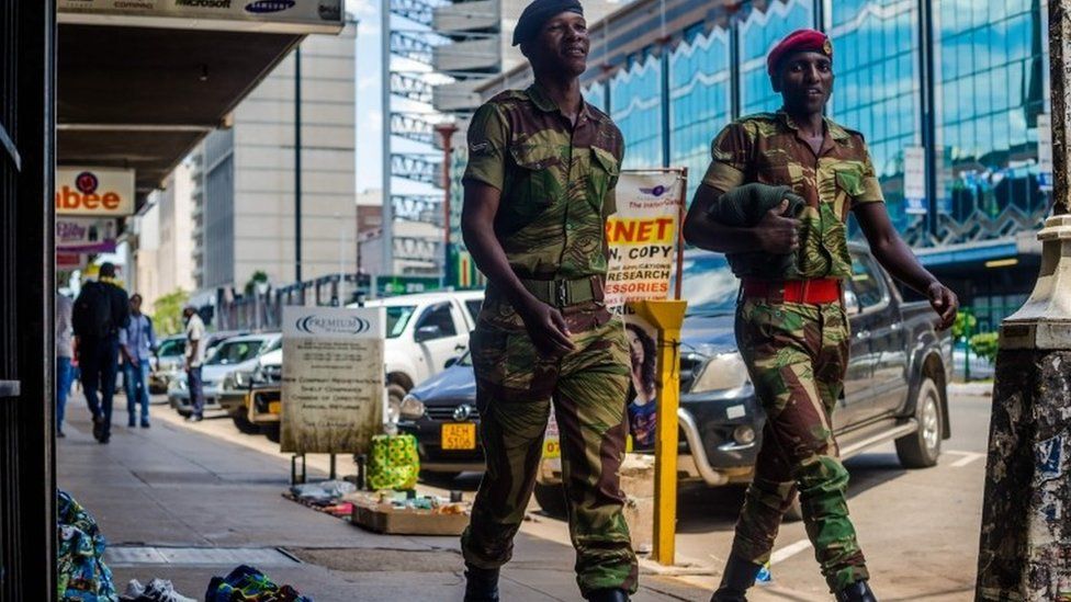 Zimbabwean soldiers walk by main streets in the Central Business District of Harare on November 20, 2017.