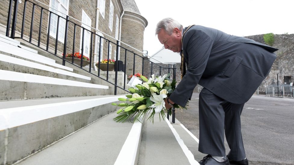 David Parry Williams laying flowers on steps