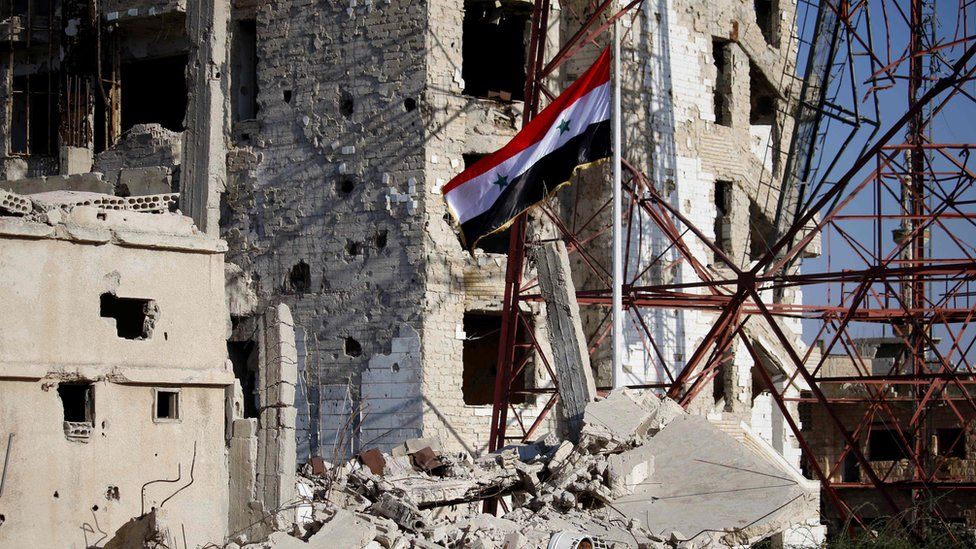 Syrian national flag flies in the previously rebel-held part of Deraa city, Syria (12 July 2018)