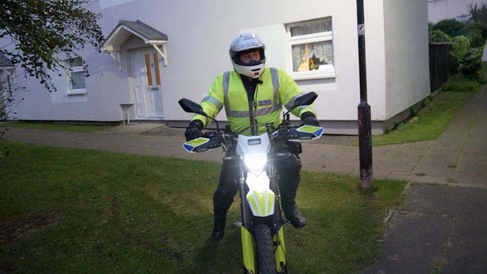 Police officer in helmet on electric motorbike