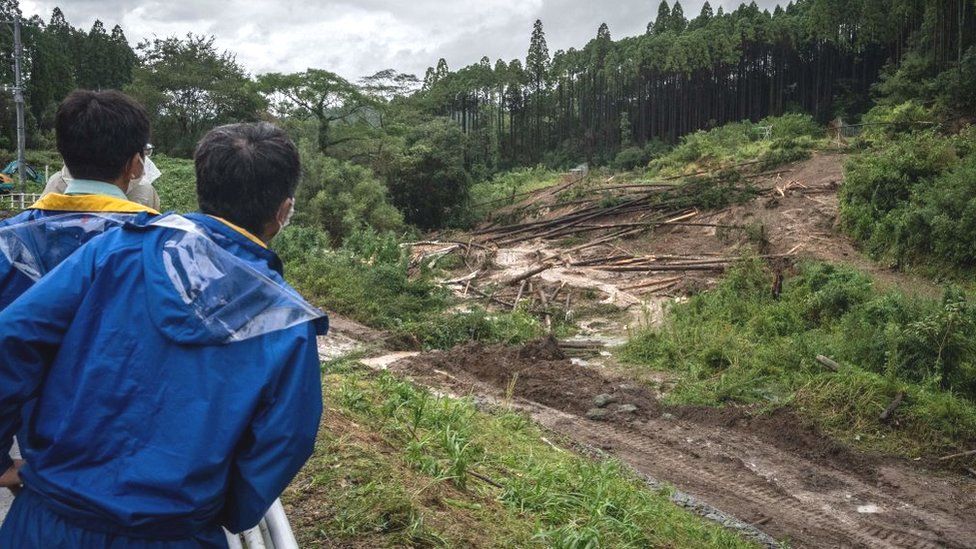 Workers survey the site of a landslide caused by Typhoon Nanmadol in Mimata, Miyazaki prefecture on September 19, 2022.
